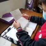 A student in Hubei Province using his new tablet and reading the letter from Lenovo CEO Yuanqing Yang.