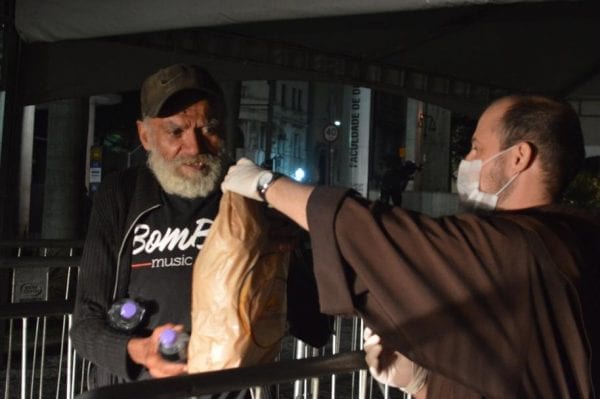 Franciscan monk giving food to the homeless in Sao Paulo