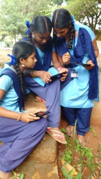 Students viewing Meghshala lessons on a Lenovo tablet.