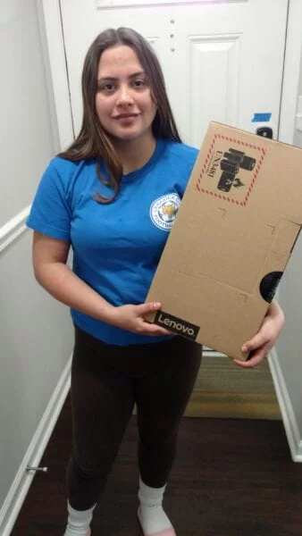 USCRI student receiving donated Lenovo PC for distance learning