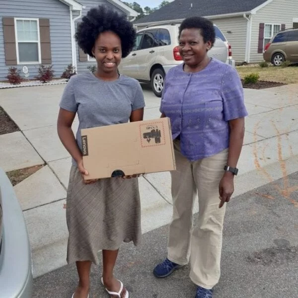 USCRI student receiving donated Lenovo PC for distance learning