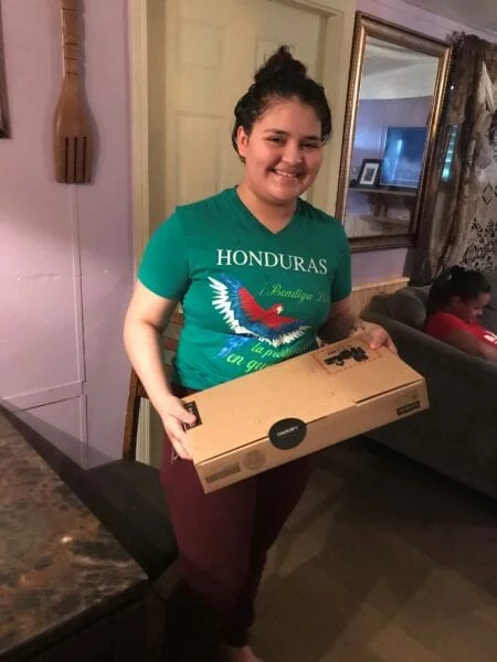 USCRI student receiving donated Lenovo PC for distance learning