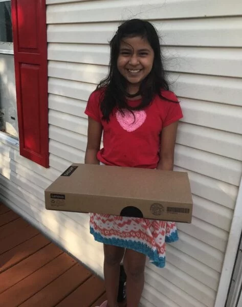 USCRI student receiving donated Lenovo PC for distance learning