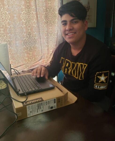 USCRI student receiving donated Lenovo PC for distance learning