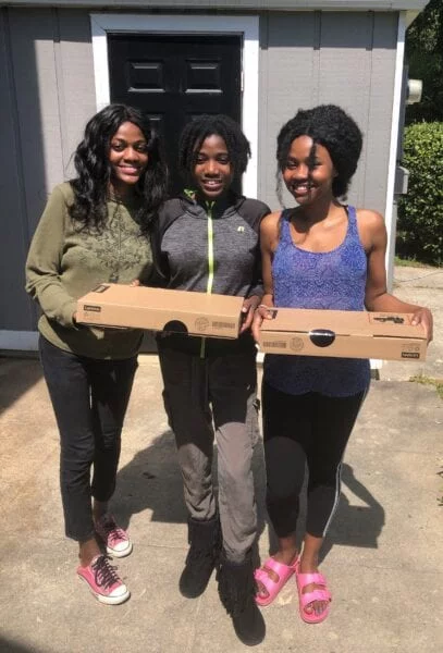 USCRI student receiving donated Lenovo PC for distance learning