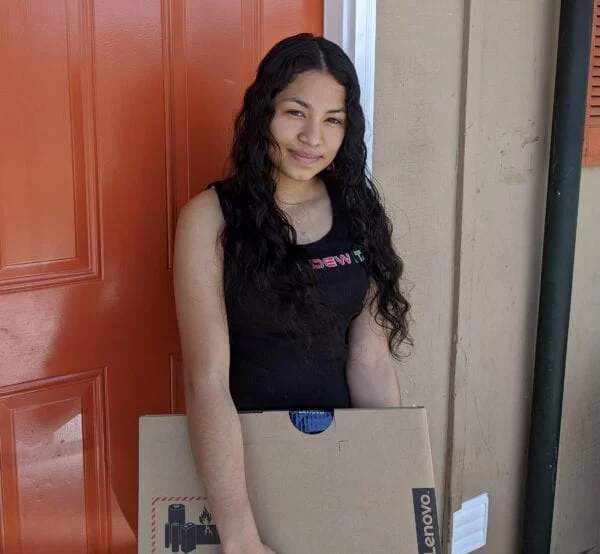 USCRI student receiving donated Lenovo PC for distance learning