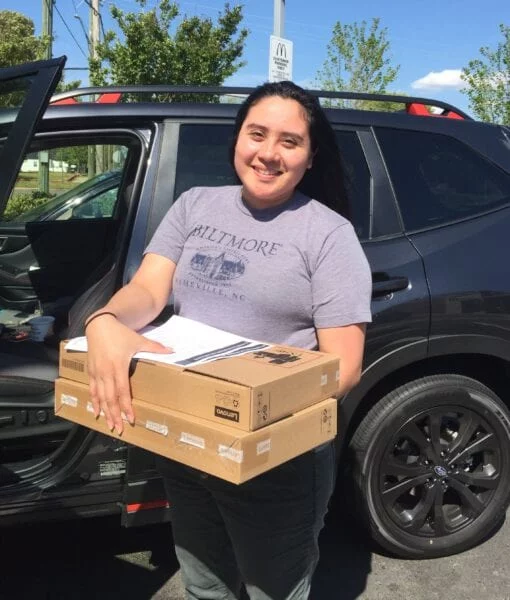 USCRI student receiving donated Lenovo PC for distance learning