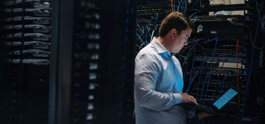 Man working on a ThinkPad in a server room.