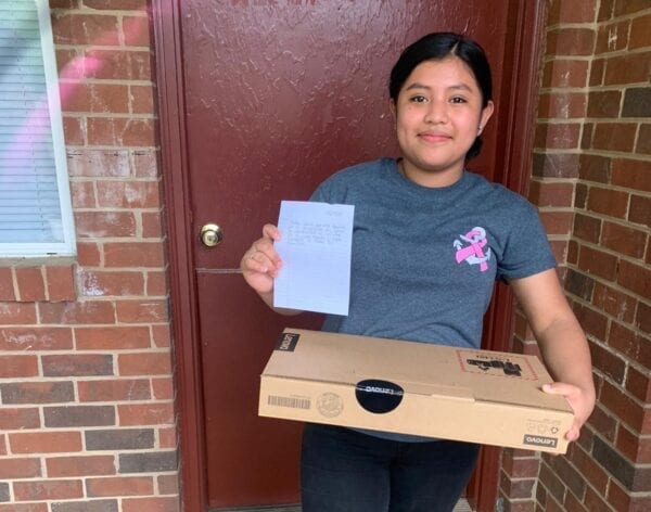 USCRI student and rising 9th grader Julissa receiving her Lenovo PC