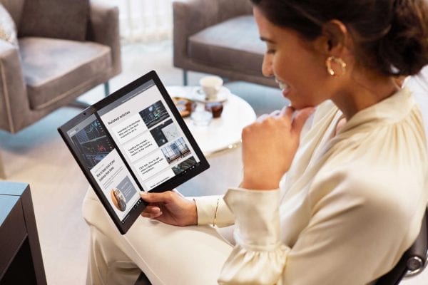 Woman sitting and reading on the Lenovo X1 Fold