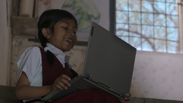 Young student with Lenovo laptop, smiling toward the screen