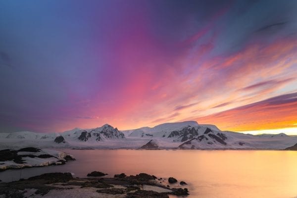 Brightly colored sunset over Antarctica's mountains.