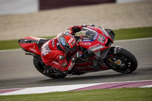 Ducati MotoGP bike in a deep lean as it races on a track.