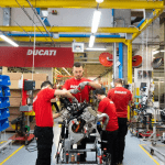 Team of Ducati mechanics and engineers working on an engine
