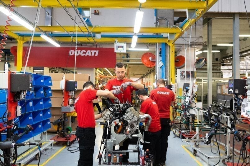 Team of Ducati mechanics and engineers working on an engine