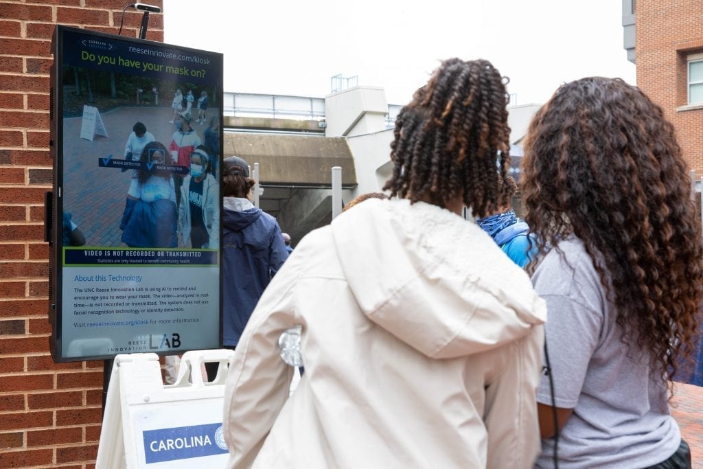 Attendees at the Oct. 10 UNC football game pass one of the Health Greeter Kiosks, which confirms two people are correctly wearing masks.