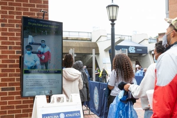 Attendees at the Oct. 10 UNC football game pass one of the Health Greeter Kiosks, which confirms two people are correctly wearing masks.