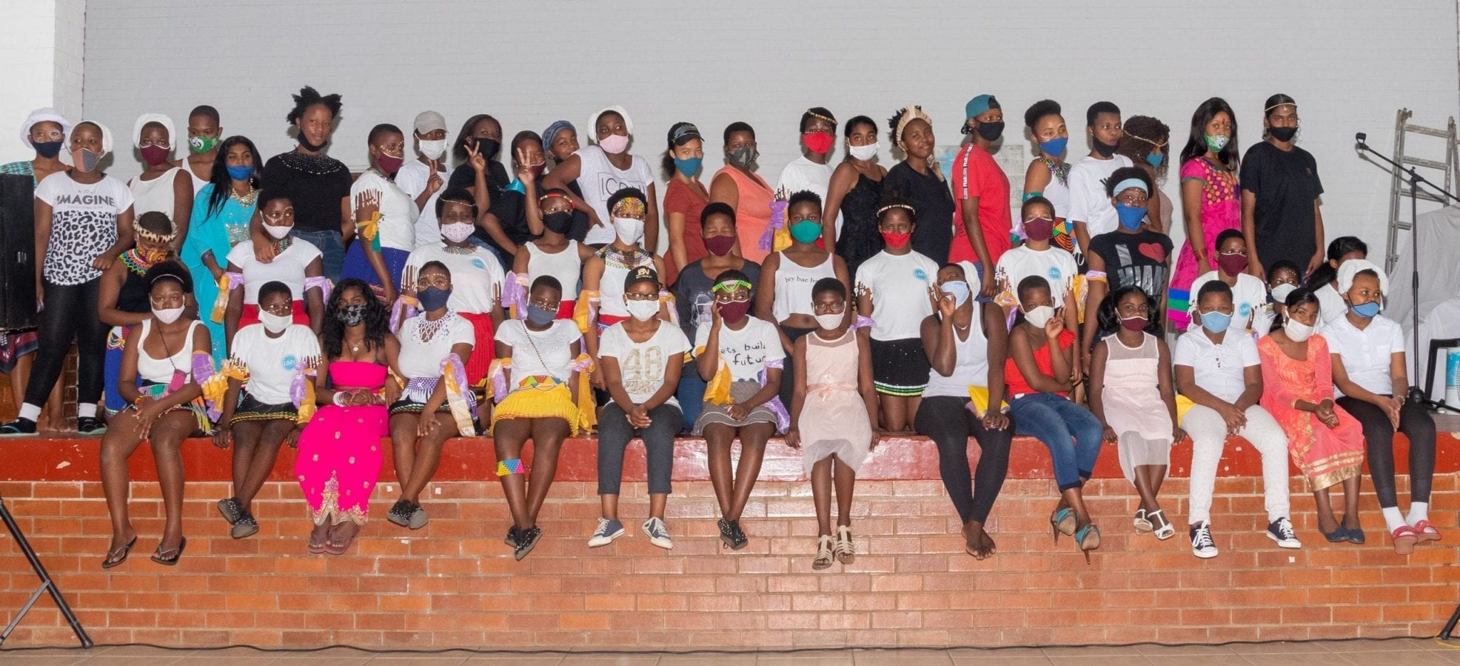 Residents of the St Monica’s Child and Youth Care Centre in South Africa sitting on stage.