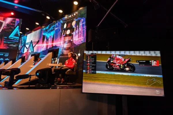 eSport tournament image with the live player at a console while a separate screen shows their view to the audience.