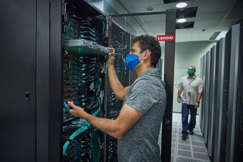 Person wearing a mask while installing new Lenovo systems for DreamWorks Animation