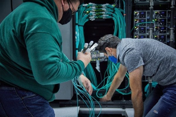Two people holding cables as they install the servers for DreamWorks Animation