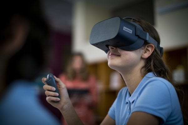 Young student wearing a Lenovo VR headset in school