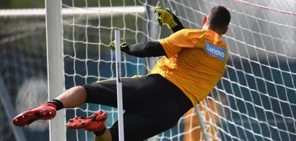 Goalkeeper wearing a Lenovo jersey attempts to save a goal
