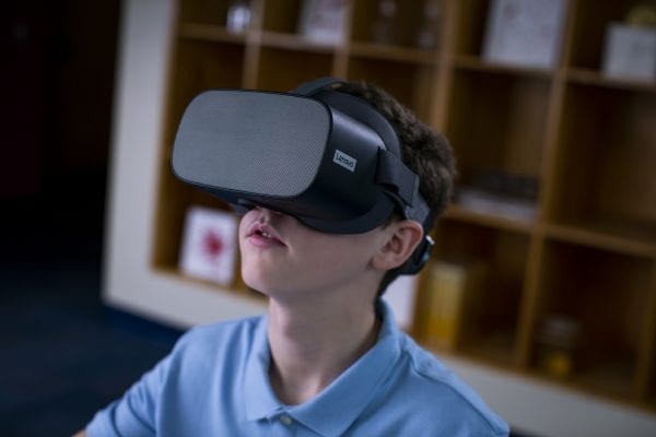 Young student using a Lenovo VR headset in the classroom.