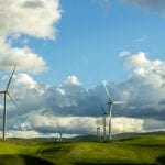 Lenovo brand image - wind turbines on low hills with a blue and partly cloudy sky