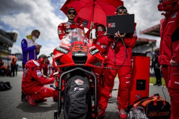 Ducati motorbike with a pit crew working and diagnosing with a Lenovo laptop plugged into the bike