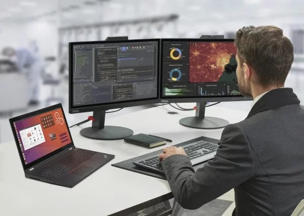 Person sitting with ThinkPad P15 Gen 2 on a desk hooked up to two external monitors.