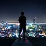 Silhouette of man overlooking Shanghai cityscape at night