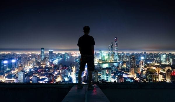 Silhouette of man overlooking Shanghai cityscape at night