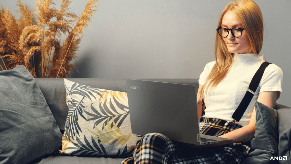 Woman sitting on a couch using a Lenovo Yoga laptop
