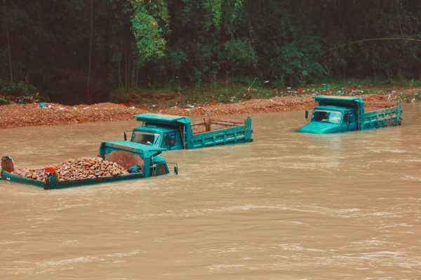 Large trucks almost entirely submerged in flood water
