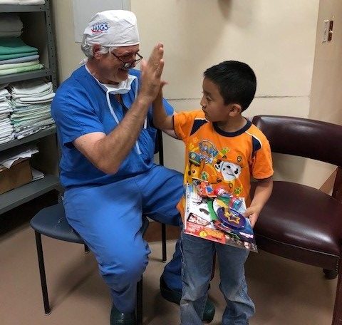 Doctor giving a high five to a young kid.