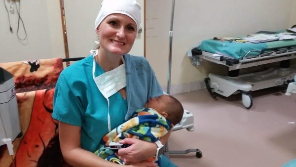 HUGS volunteer holding a baby