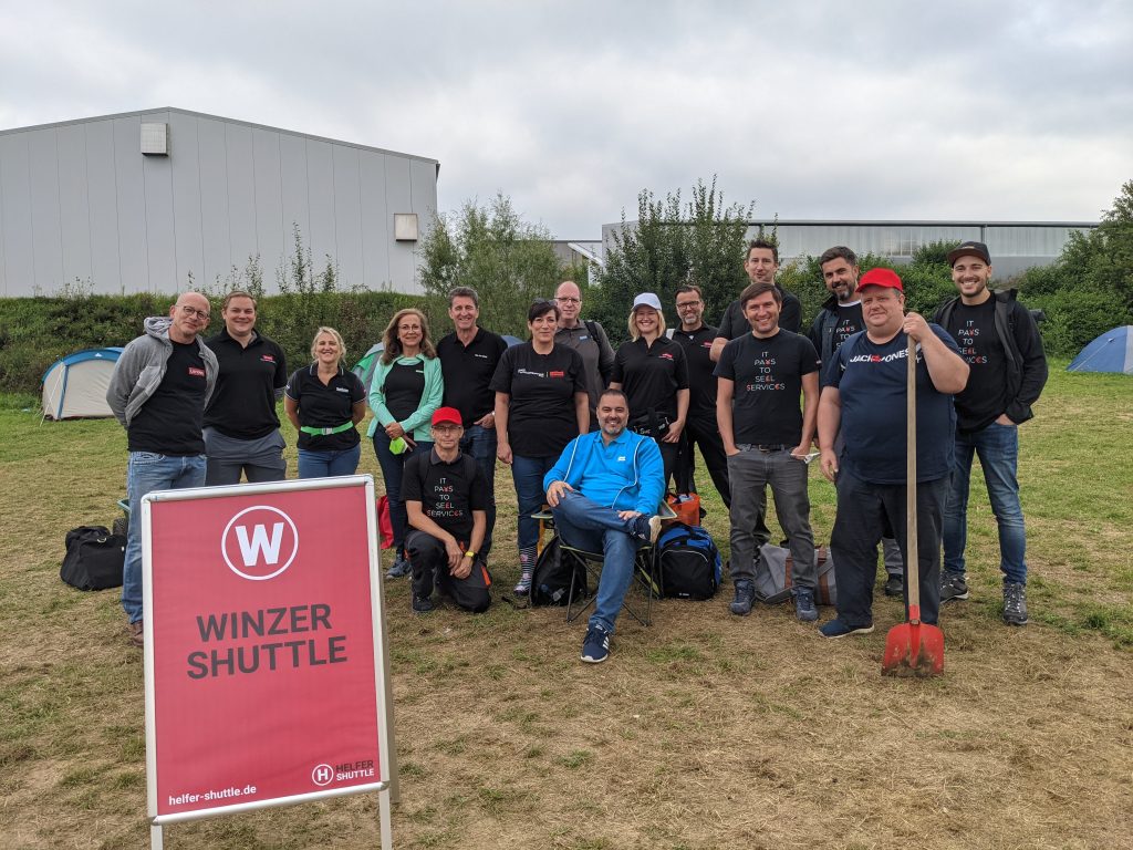 Lenovo volunteers gathered by a sign reading "WINZER SHUTTLE"