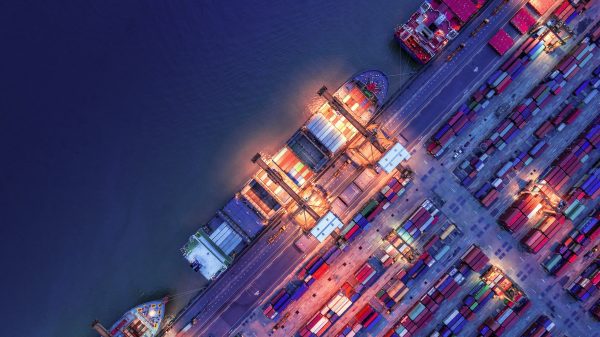 Aerial view of a cargo container shipyard at night.