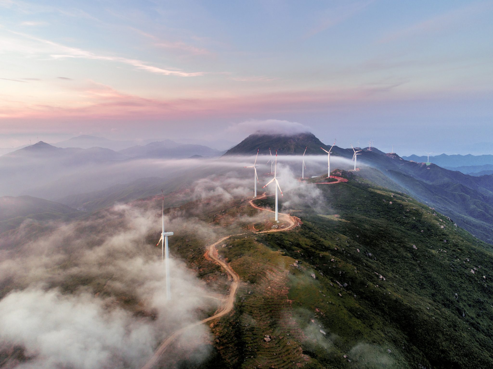 Mountain with multiple wind turbines.
