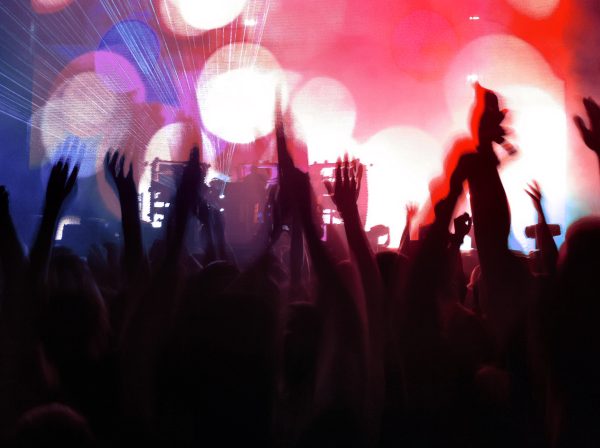 brand image- Crowd of fans, shot from behind with hands up in the air at a rock concert.