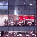 brand image - View through the windows of people working late in large office tower.