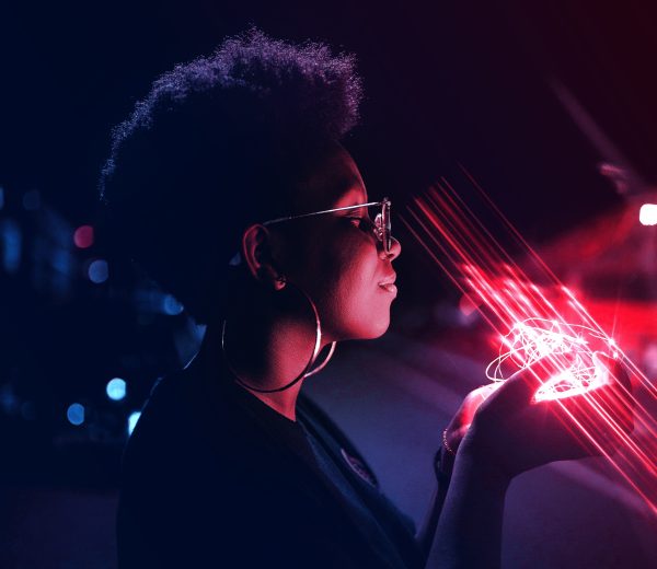 brand image - Profile of African-American woman holding string of small red led lights in the dark.