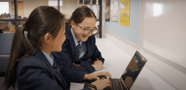 Students using a Lenovo laptop at All Saints College