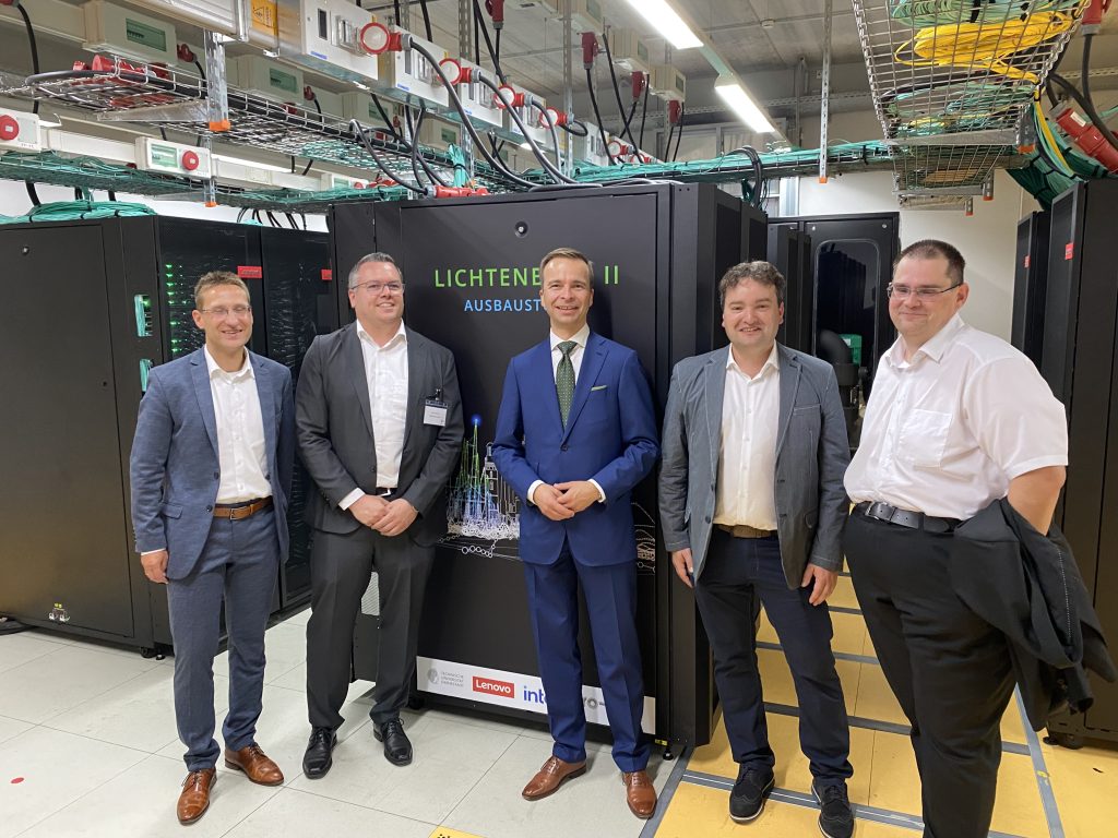 five businessmen standing in front of a super computer in a server room