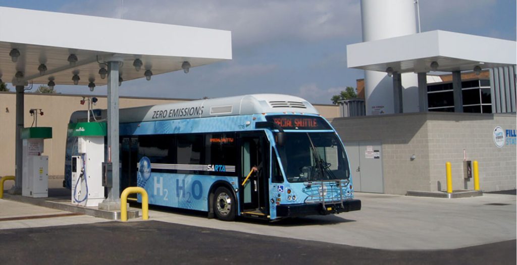 Bus at station refueling on 100% renewable energy