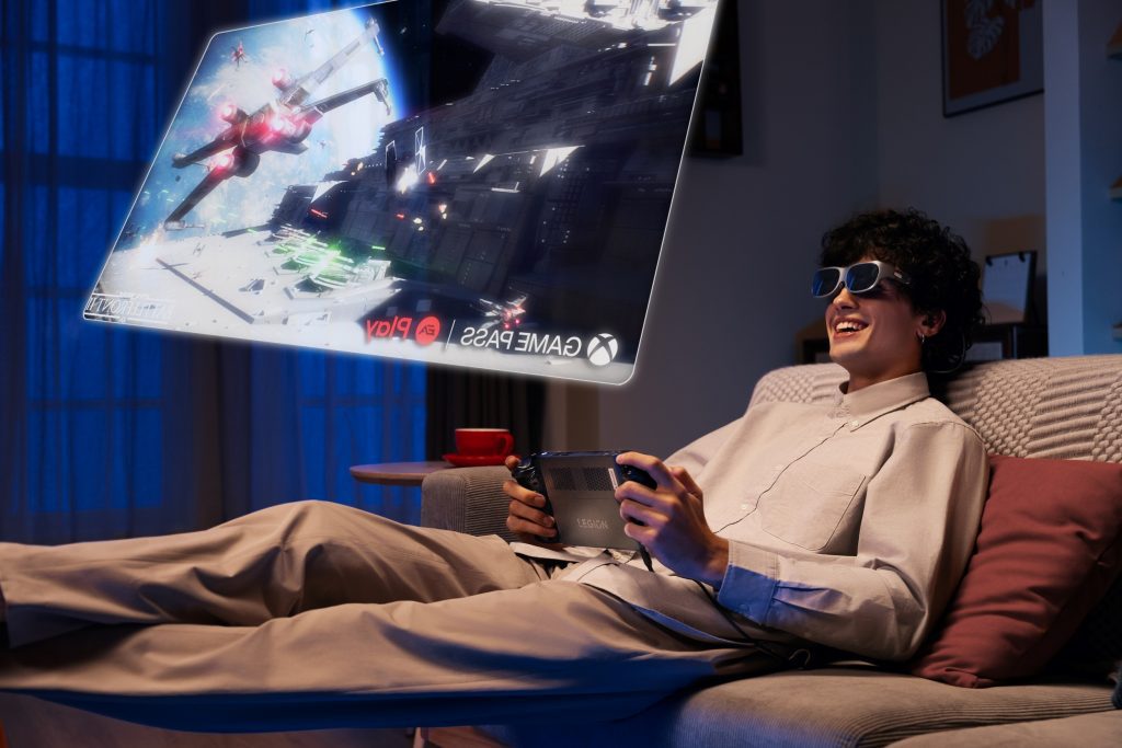 Une personne allongée sur un canapé utilisant Legion Go avec des lunettes Legion