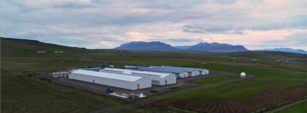 Datacentre buildings in green field, sunset skyline in Iceland