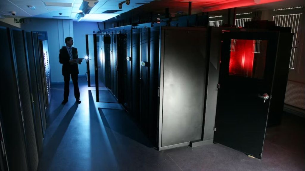 Man in dark server room with blue and red lights