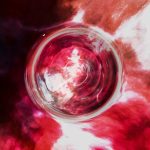 Abstract image of a black hole in space with red and white clouds around